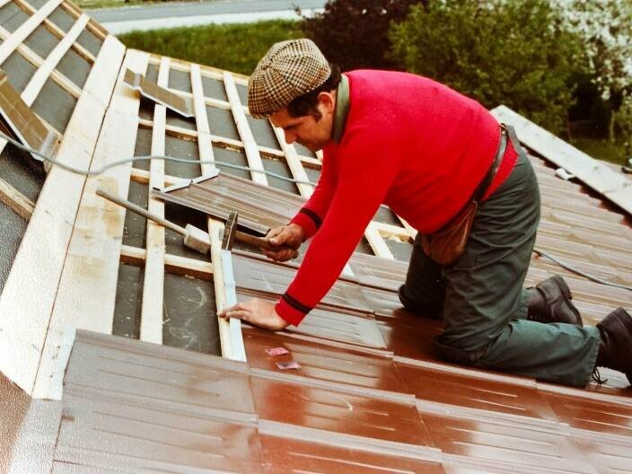 Der junge Heinrich Wochner deckt das Dach des neuen Eigenheims mit der roten Dachplatte ein. Das Eigenheim des Paars war der Wegbereiter für farbige Dächer.