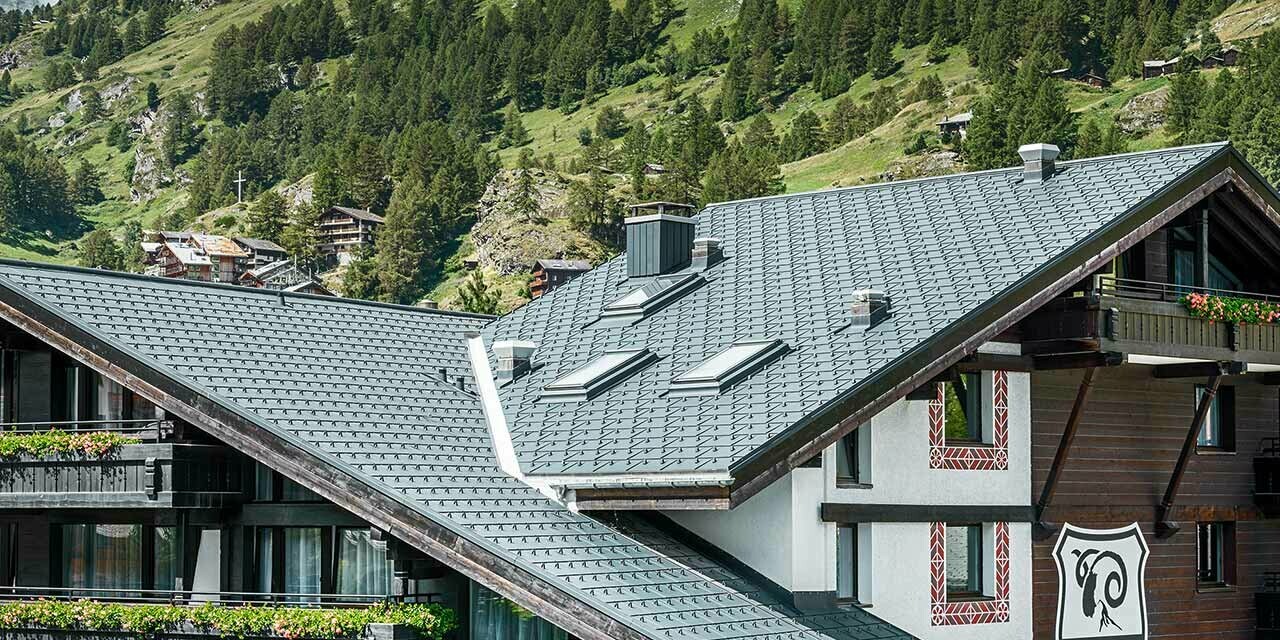 Hotelalpenhof a Zermatt con il Monte Cervino sullo sfondo, balconi, facciata in legno scura e una coperura in alluminio PREFA in antracite