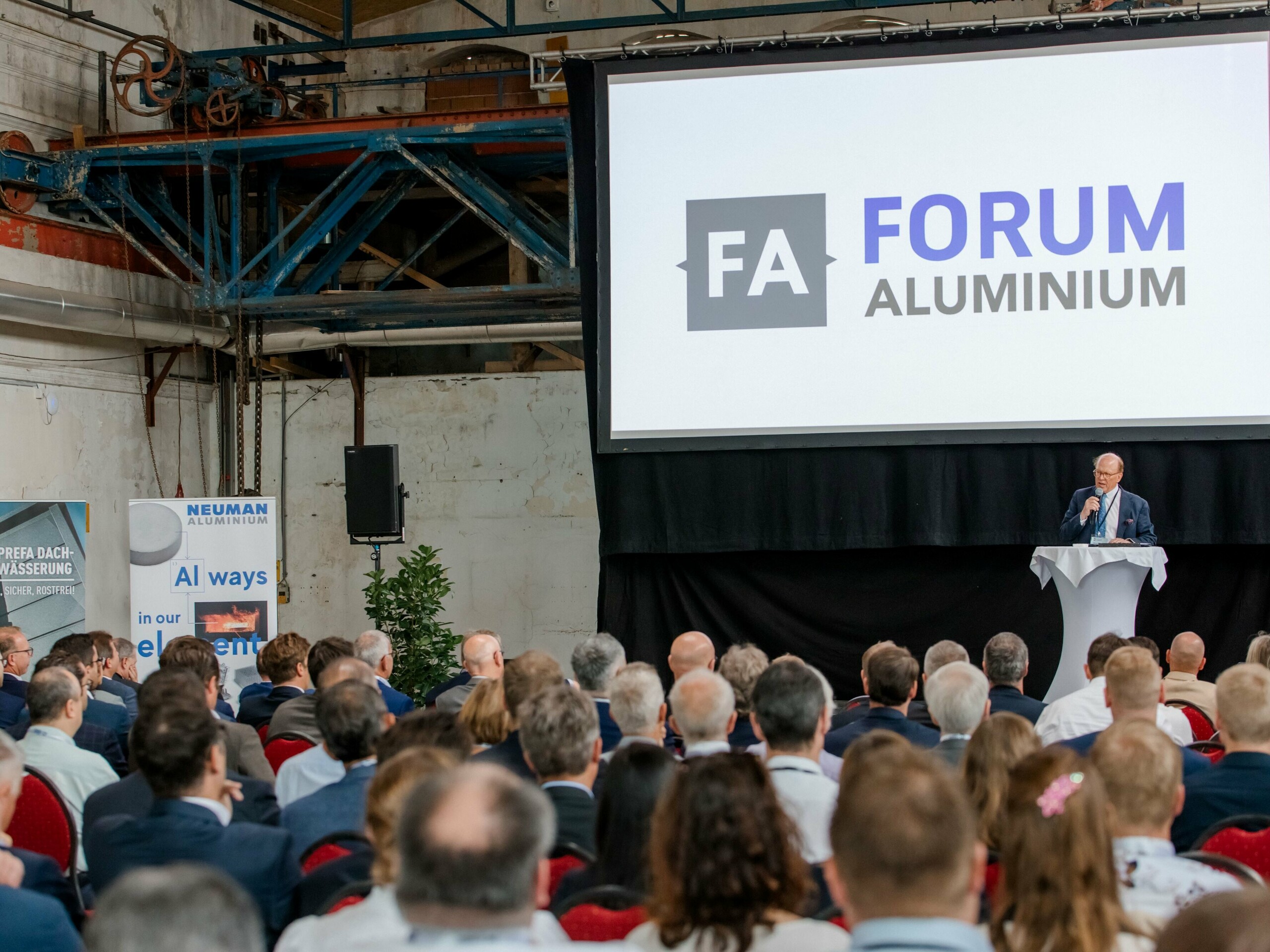 Bild einer Präsentation, auf der Leinwand ist "Forum Aluminium" abgebildet.