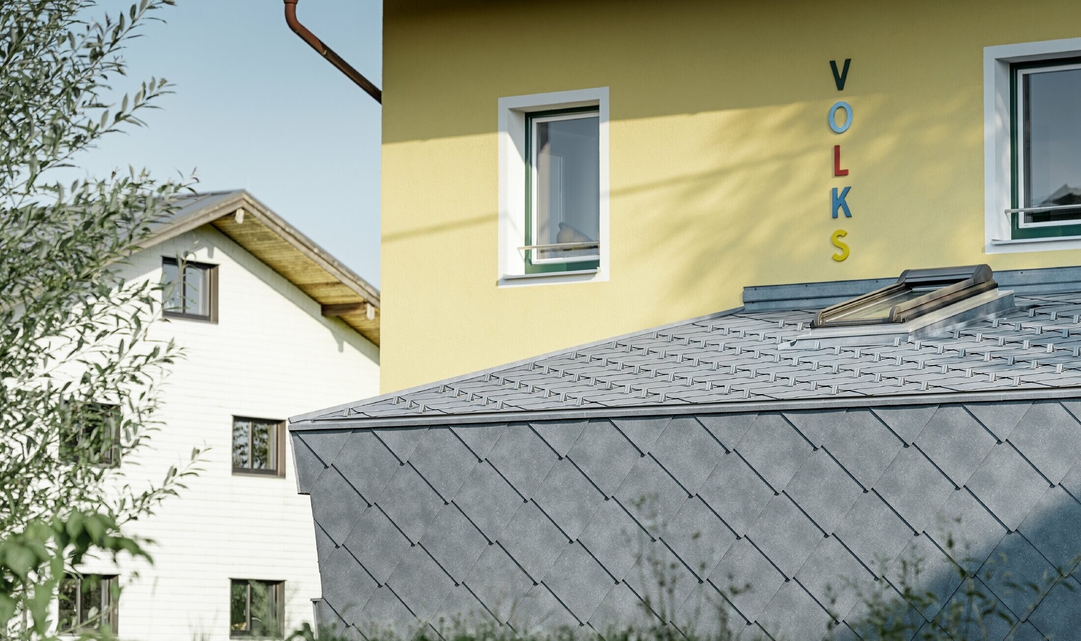 Annessione a una scuola elementare rivestita con scaglia per copertura e facciata in alluminio di PREFA in grigio pietra