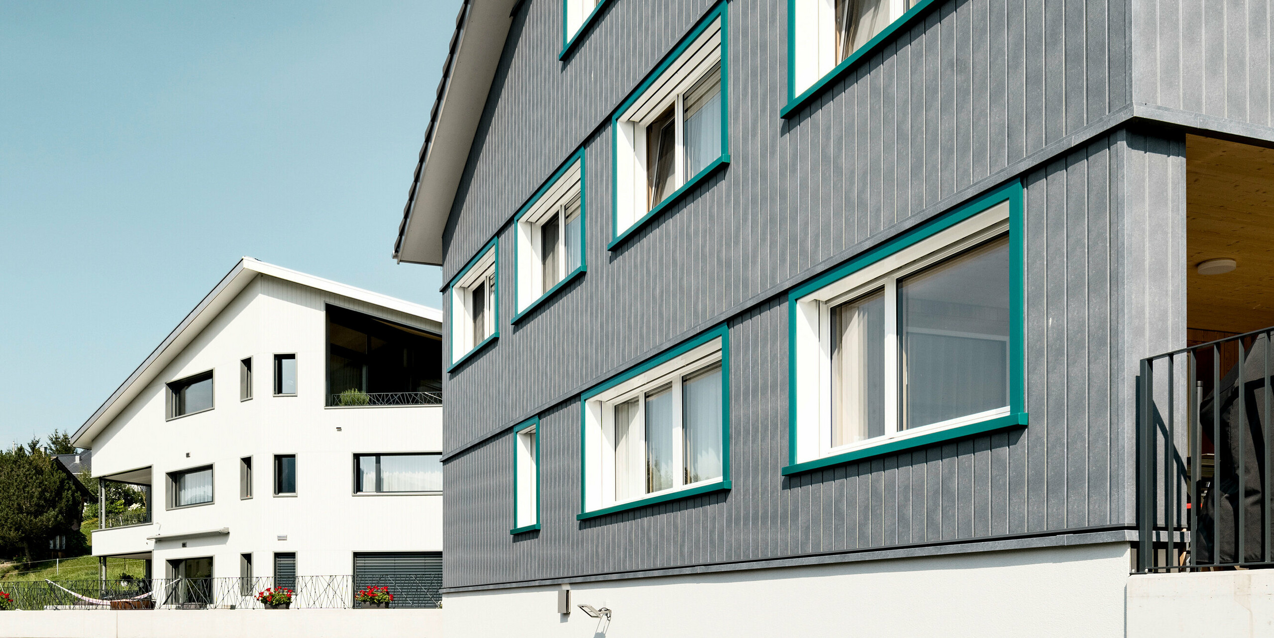 PREFA Sidings in P.10 Steingrau bzw. P.10 Prefaweiß an den Fassaden von zwei benachbarten Mehrfamilienhäusern in Weissbad, Schweiz.