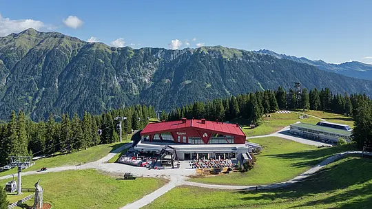 Rifugio e ristorante Summit Mountain Club in primavera circondato dai prati verdi. A 1.830 metri, vicino alla stazione a monte Rinneralm (2.100 m), il Summit Mountain Club si posiziona come nuovo punto di riferimento per gli appassionati di sport invernali e gli ospiti estivi e, sempre più, come luogo per eventi aziendali e riunioni.