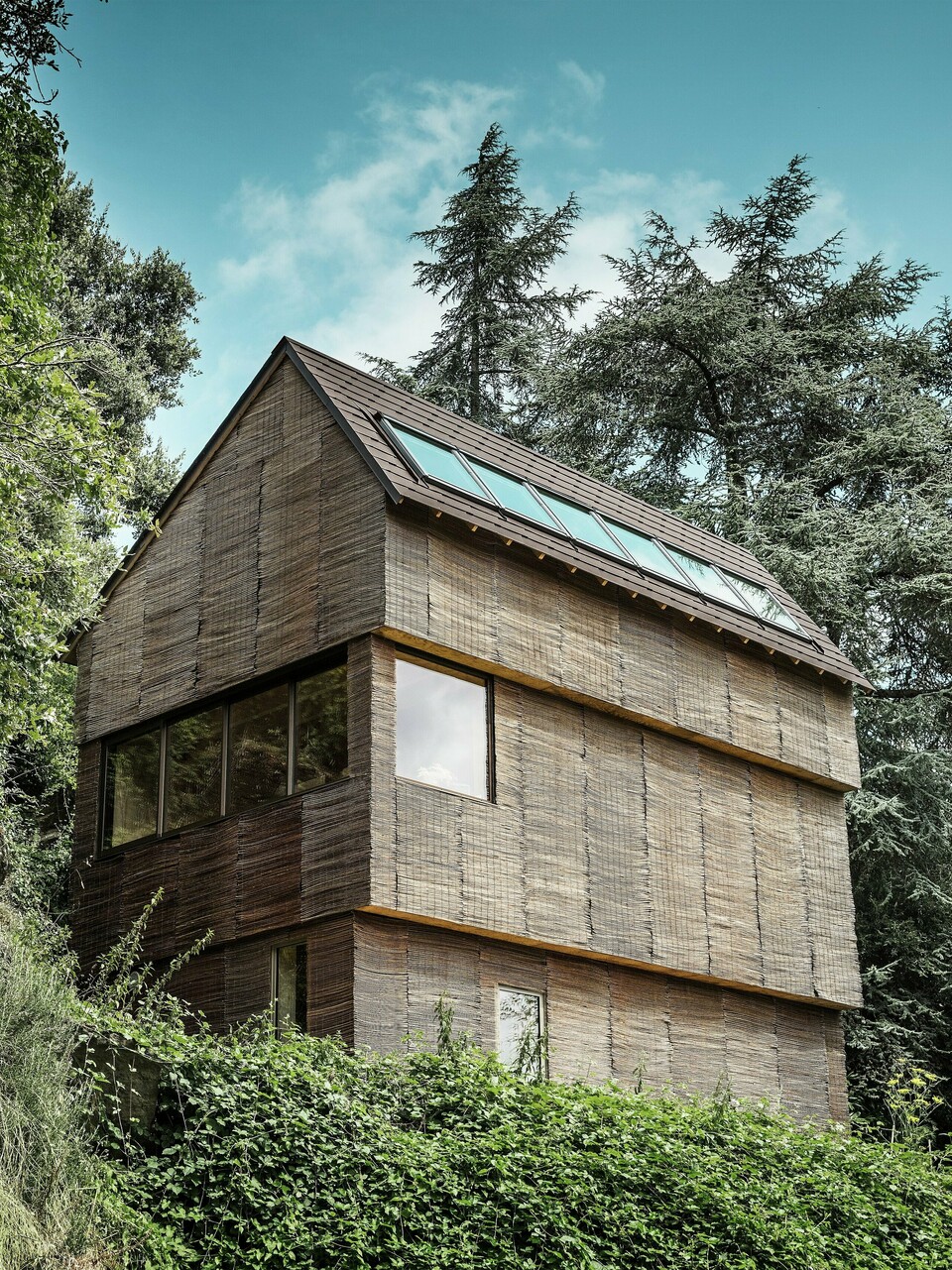 Casa nell'ovest della Francia con scandole PREFA in P.10 testa di morosu una collina scoscesa - design moderno con facciata in salice e tetto ad alta efficienza energetica.