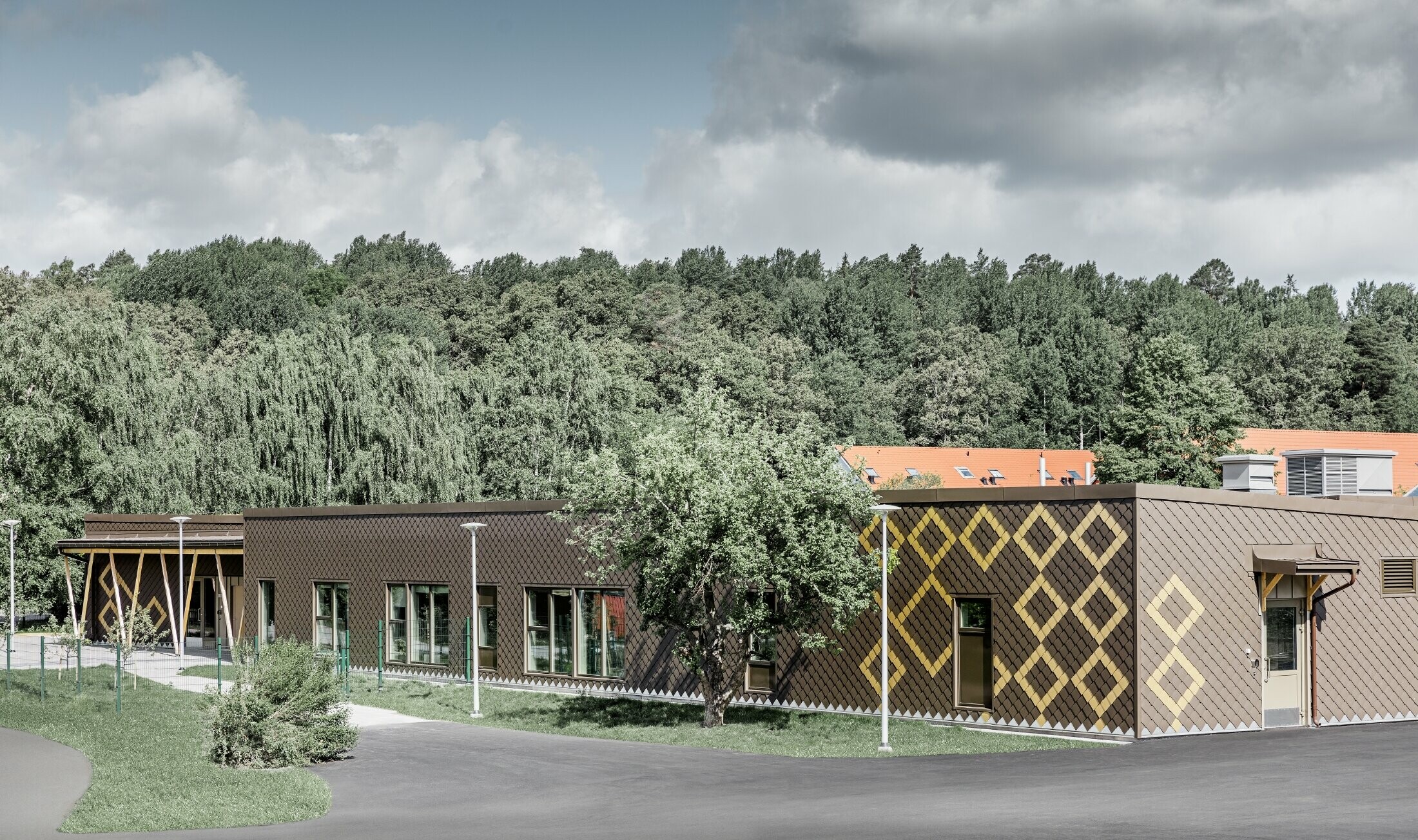 Il rivestimento della facciata di una scuola materna di Stoccolma è stato realizzato con le resistenti losanghe 20 PREFA di colore marrone e mayagold.