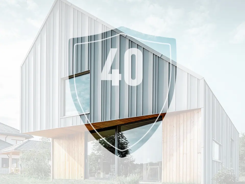 Das Bild zeigt ein Schild mit der Zahl "40", welche die Garantie auf PREFA Aluminiumprodukte darstellen soll, vor einem modernem Einfamilienhaus.