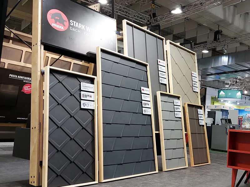 Stand fieristico PREFA con espositori che mostrano prodotti in alluminio PREFA già posati.