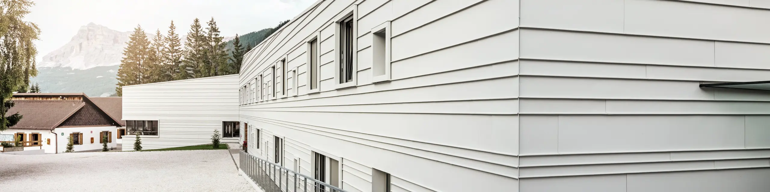 La moderna architettura della caserma “Tempesti” fa una dichiarazione di stile con PREFALZ nel colore P.10 bianco PREFA. Le lastre in alluminio posate in orizzontale conferiscono alla struttura un aspetto pulito. Il colore chiaro riflette la luce, migliorando il microclima nell'ambiente alpino.