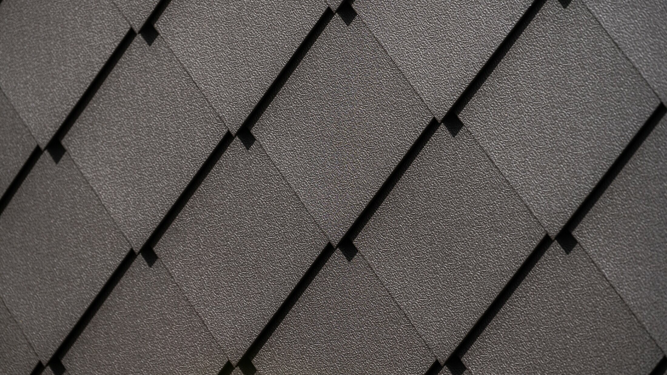 Scaglia per facciata PREFA 29 × 29 in testa di moro, primo piano con superficie goffrata