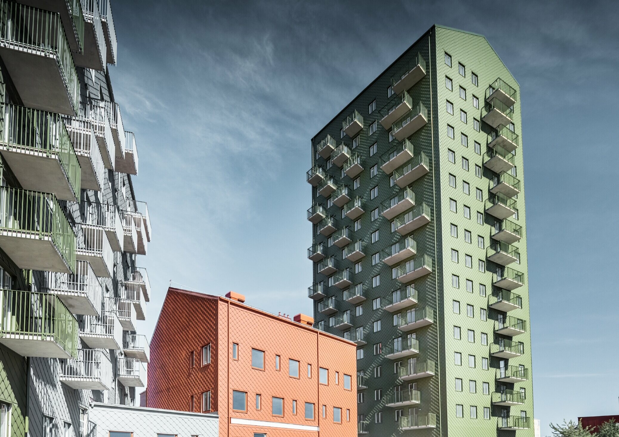Diverse abitazioni rivestite con la scaglia 29 di PREFA nei colori verde oliva, rosso cotto e grigio chiaro a Göteborg, Svezia.