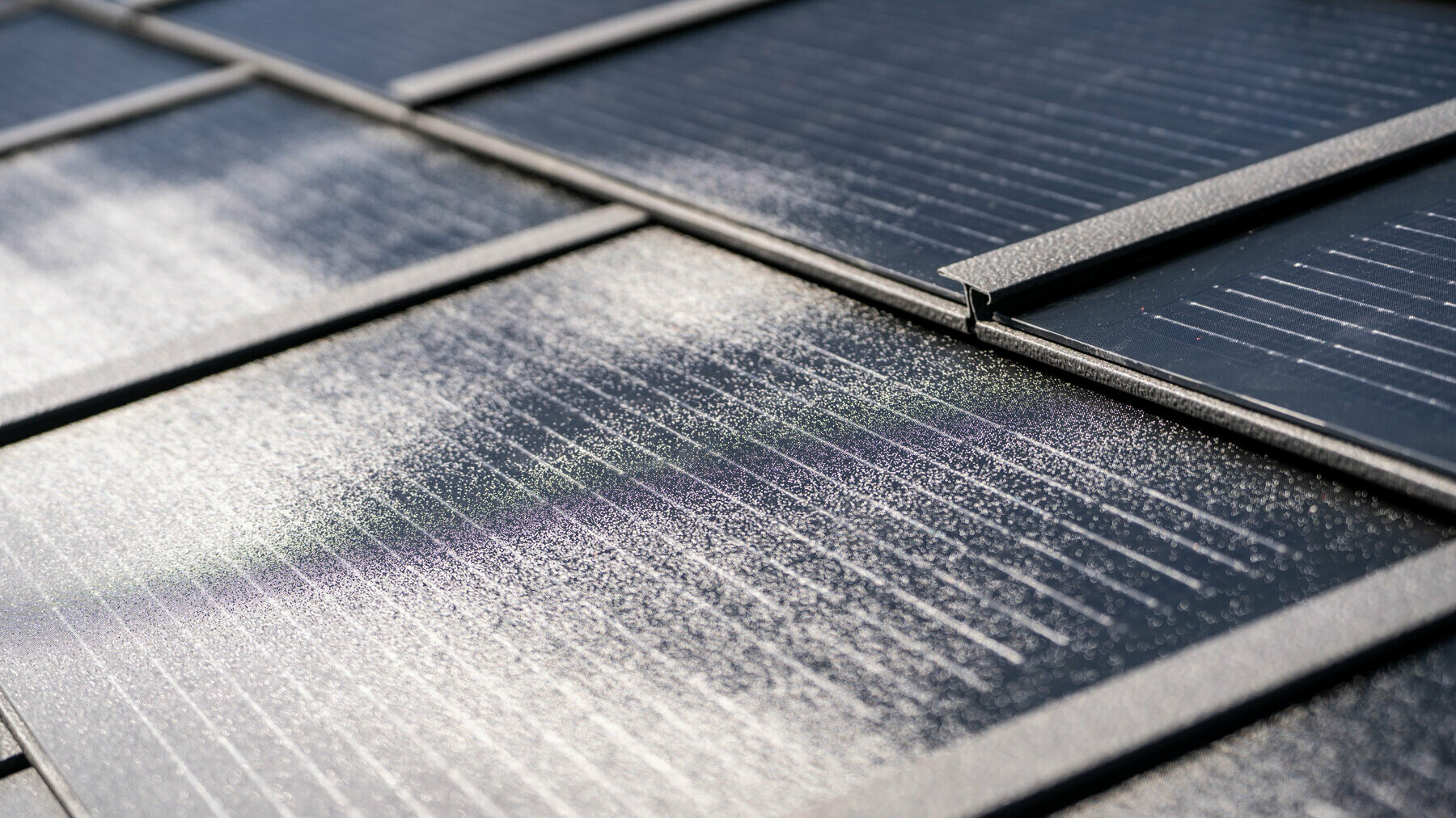Particolare della tegola fotovoltaica PREFA piccola posata e della tegola R.16 nel colore P.10 grigio scuro.