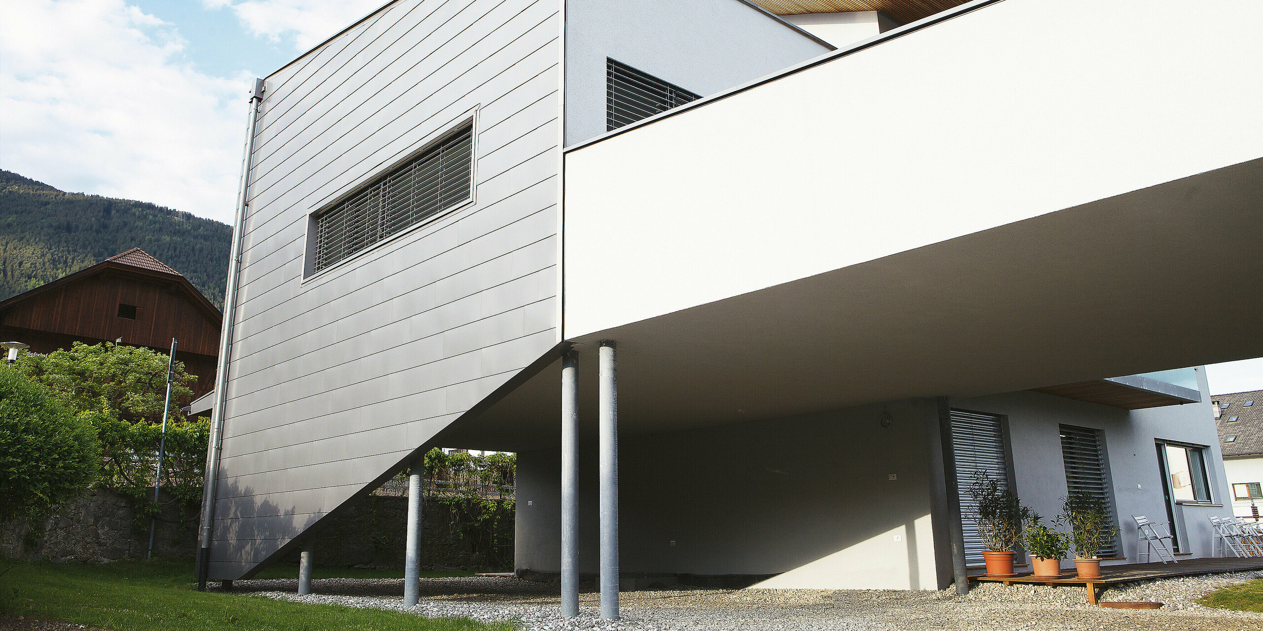 Die Rückansicht des Hauses in Pfalzen zeigt die durchgehende PREFALZ Fassadenbekleidung. Die langlebige PREFA Oberfläche trotzt Wind und Wetter und bleibt wartungsarm - ideal für anspruchsvolle Bauherren, die Wert auf Qualität und Design legen.