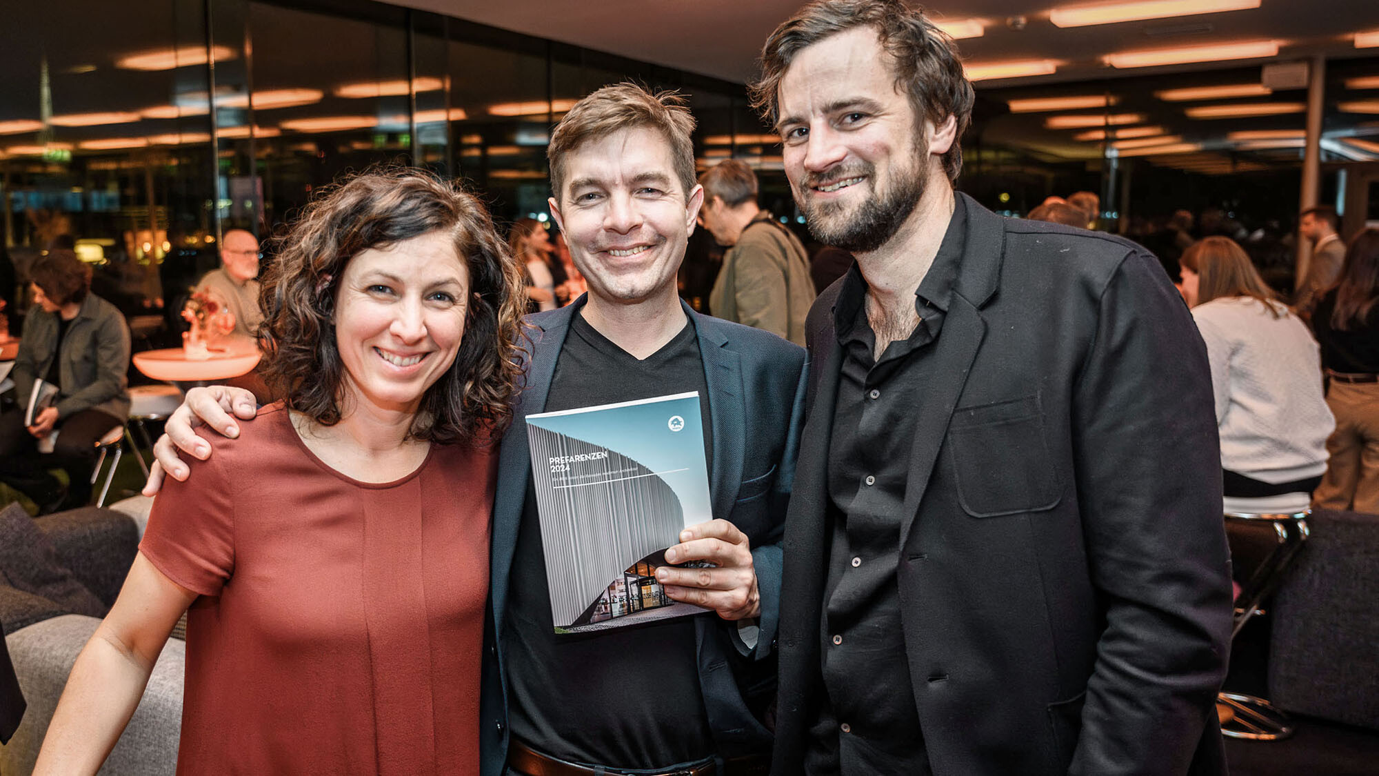 L'architetto Claudia Gast, l'architetto Mario Dallaserra con in mano il libro PREFARENZEN 2024, e l'installatore Simon Mössler.