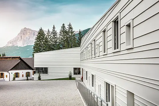 Luce chiara, linee nette: la facciata della caserma “Tempesti” in Alto Adige dimostra in modo impressionante come il design moderno si integri nel paesaggio montano. Le lastre orizzontali PREFALZ nel colore P.10 bianco PREFA riflettono la luce solare, migliorano il microclima e convincono per la loro qualità robusta e durevole. Sono un esempio lampante di architettura militare ben studiata con l'alluminio.