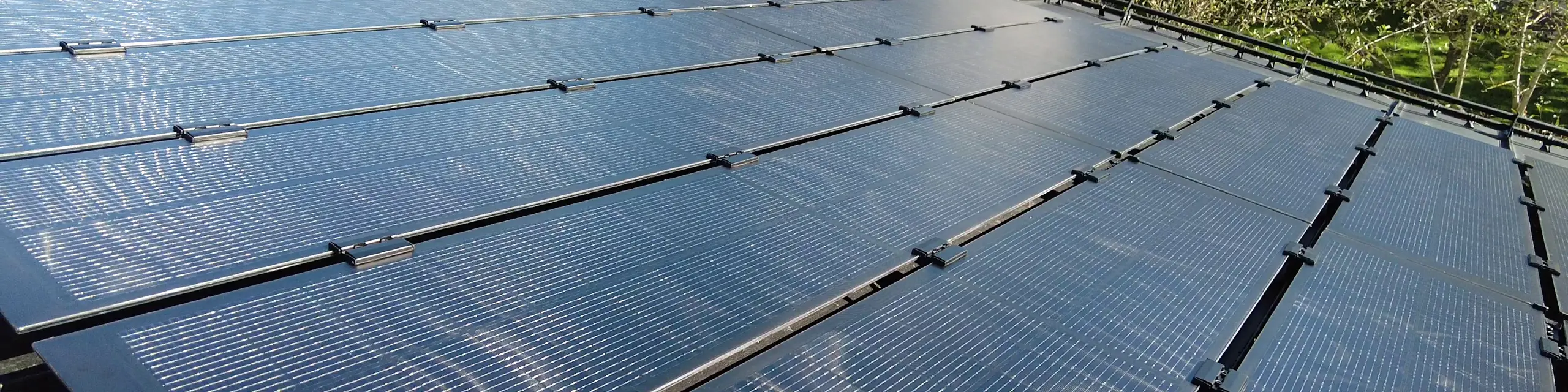 Vista di un tetto dotato di moduli fotovoltaici PREFALZ, con moduli fotovoltaici vetro/vetro adattati con precisione alle larghezze delle lastre in doppia aggraffatura.