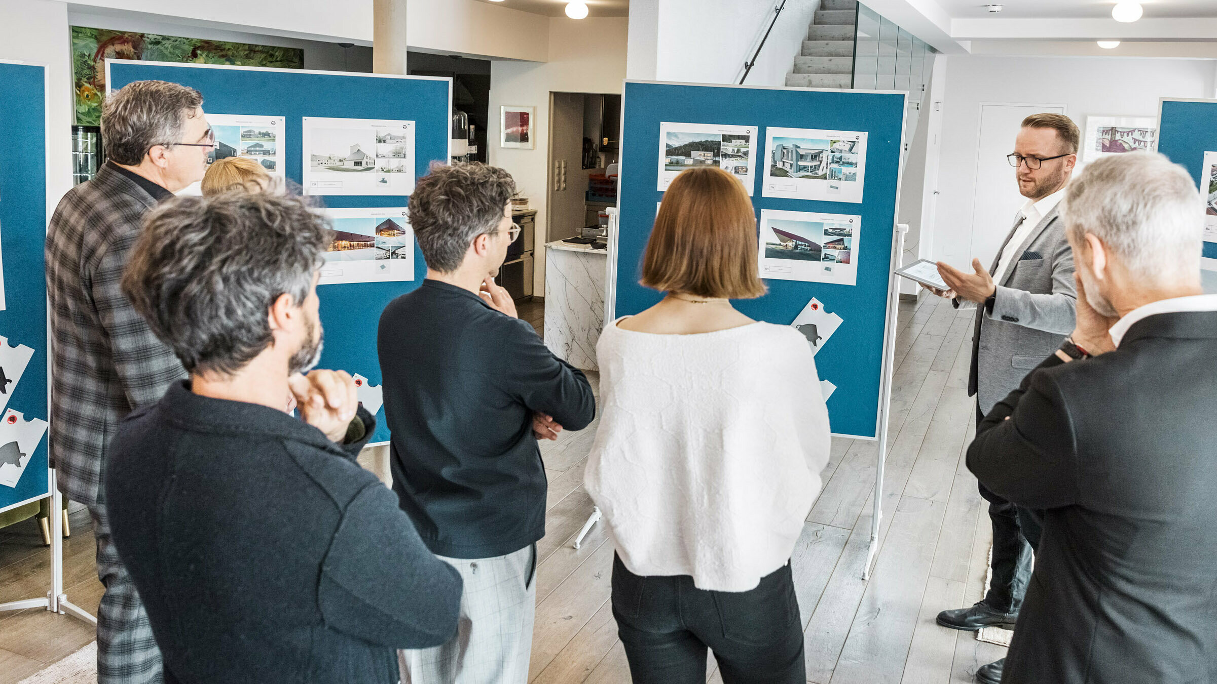 Ein Teil der Experten-Jury sieht sich die aufgehängten Projektblätter an.