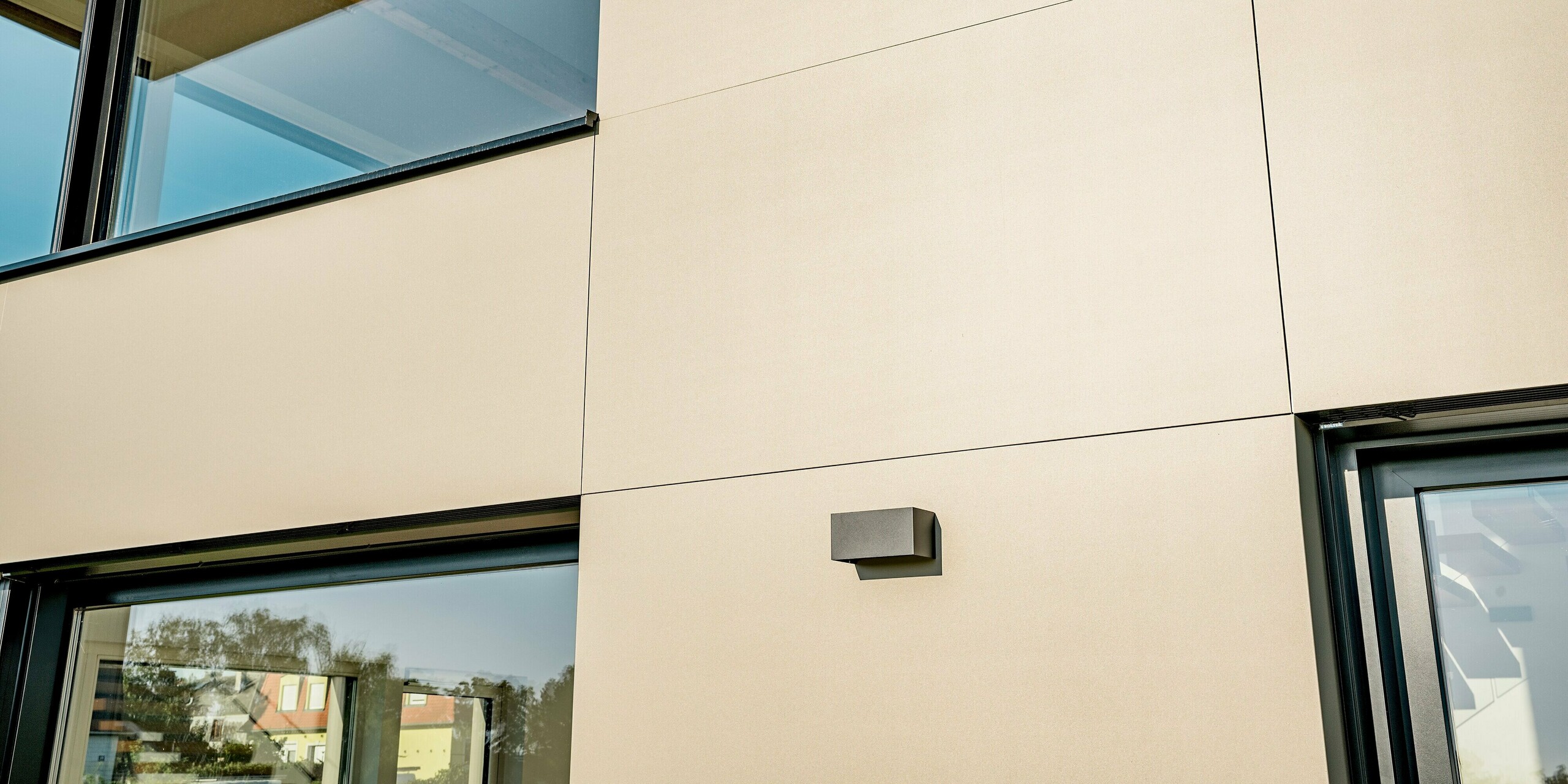 Nahaufnahme des modernen Betriebsgebäudes des Weinguts Nigl in Perchtoldsdorf mit eindrucksvoller PREFA Aluminiumfassade in P.10 Prefabronze. Die klar strukturierte Oberfläche der Aluminium Verbundplatten sorgt für ein elegantes, reduziertes Erscheinungsbild. PREFA Verbundplatten überzeugen hier nicht nur optisch, sondern auch durch hohe Witterungsbeständigkeit, Langlebigkeit und Wartungsfreiheit.