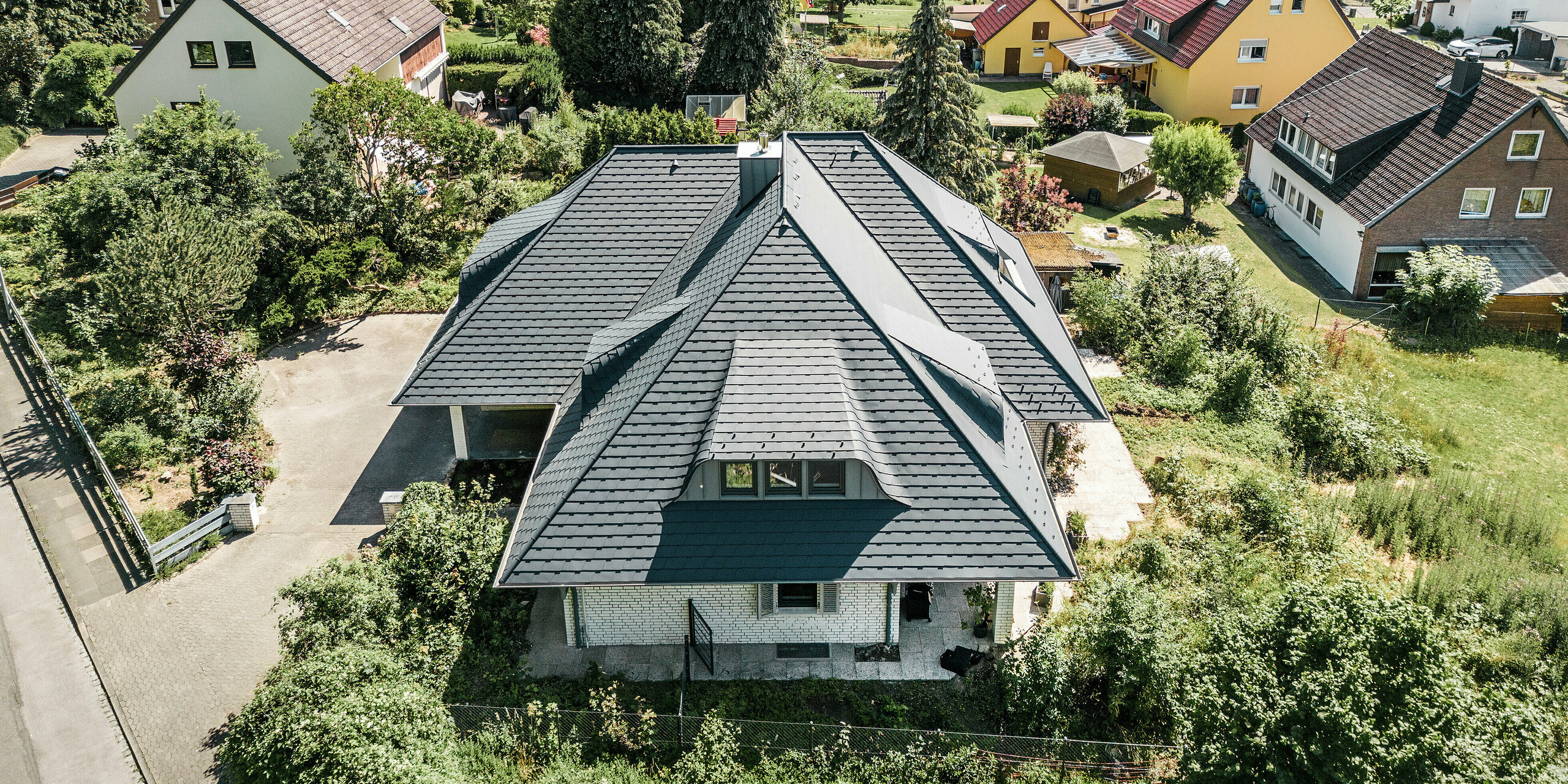 Vogelperspektive auf Dach von Einfamilienhaus mit PREFA Dachschindeln in P.10 Anthrazit