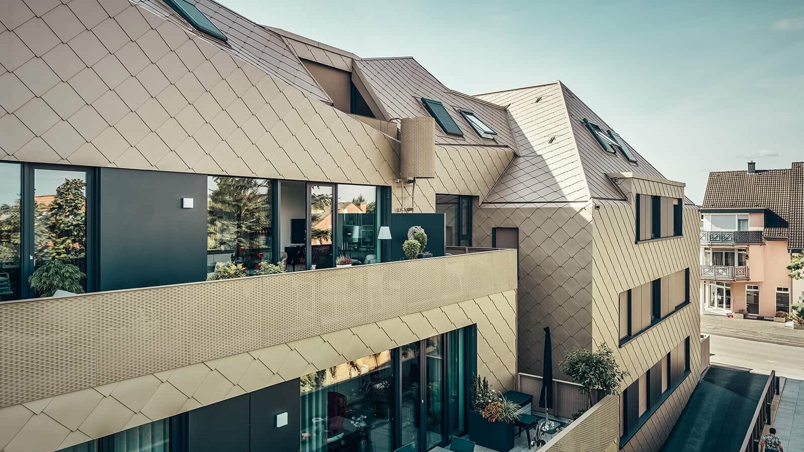 Eine Seitenansicht zeigt die kristalline Dachform und das rautenförmige Design der PREFA Lösungen.