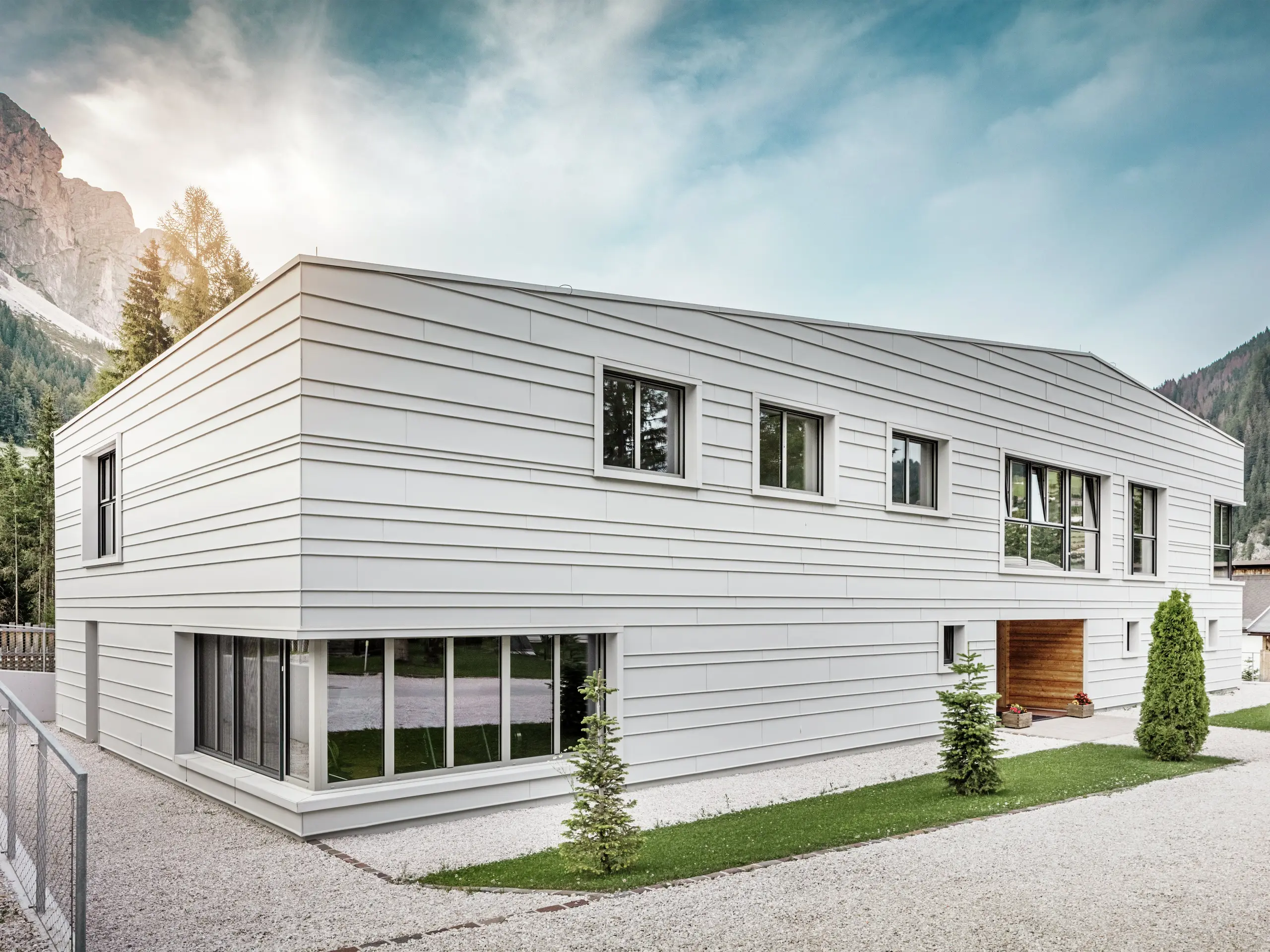La facciata moderna della caserma “Tempesti” in Alto Adige colpisce per la sua geometria chiara e i pannelli aggraffati PREFALZ di alta qualità nel colore P.10 bianco PREFA. L'alluminio utilizzato riflette la luce, regola il microclima e offre una protezione duratura. Un vero e proprio richiamo visivo è l'ingresso rivestito in legno, che conferisce calore e apertura al rigoroso ambiente militare.