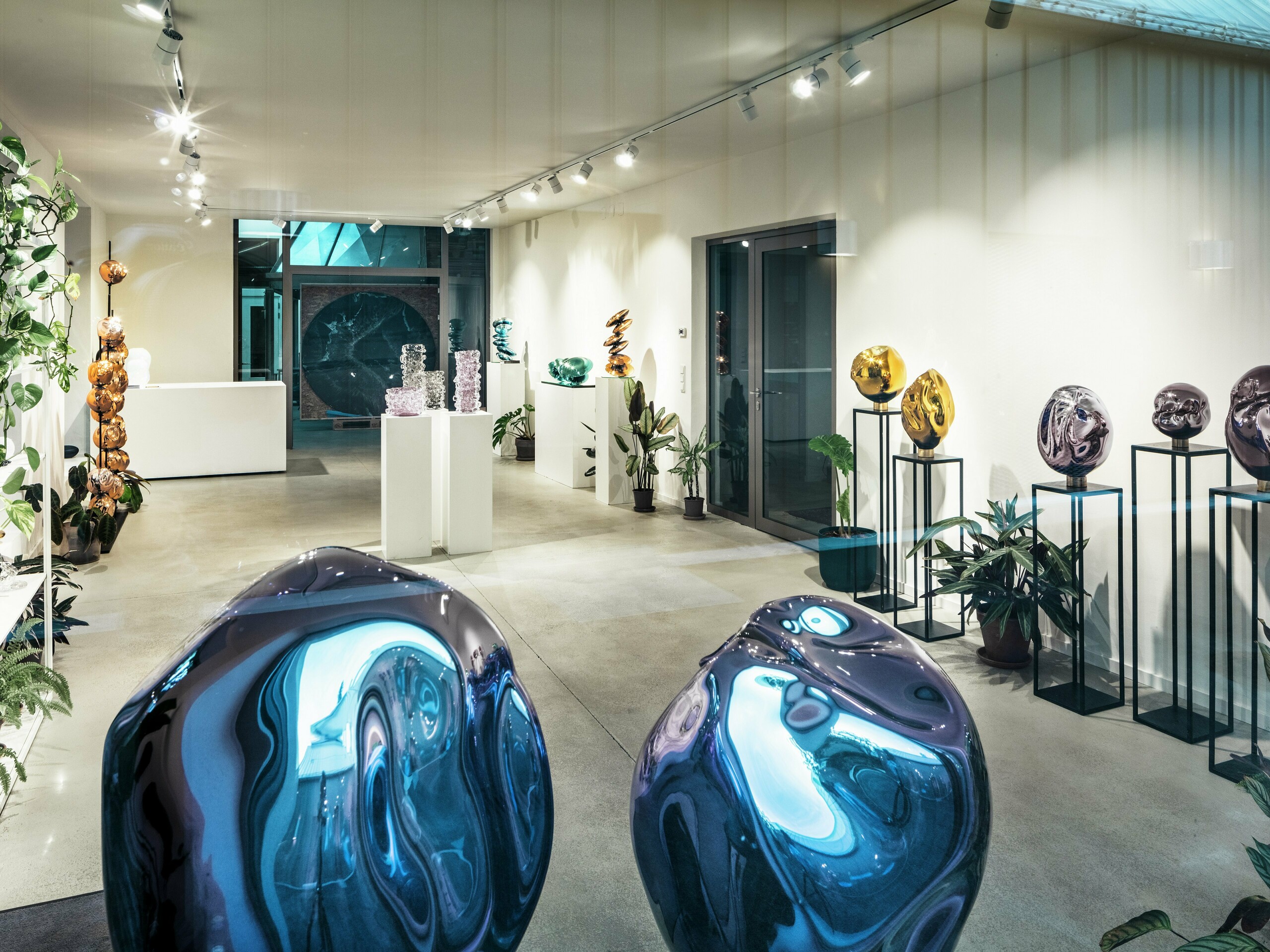 Vista interna dello Studio Comploj di Vienna con una mostra di oggetti in vetro fatti a mano. Il moderno spazio della galleria combina arte, design e artigianato in un ambiente elegante.