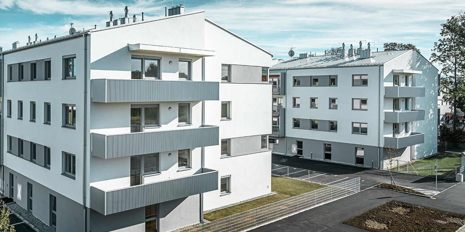 Moderno condominio con facciata bianca e balconi con profilo a zeta PREFA in silver metallizzato