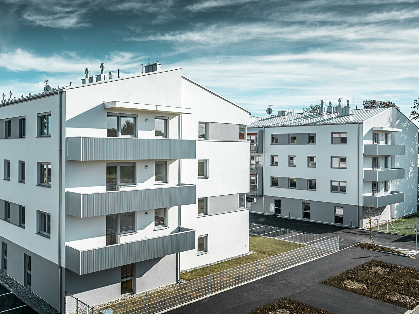 Moderno condominio con facciata bianca e balconi con profilo a zeta PREFA in silver metallizzato