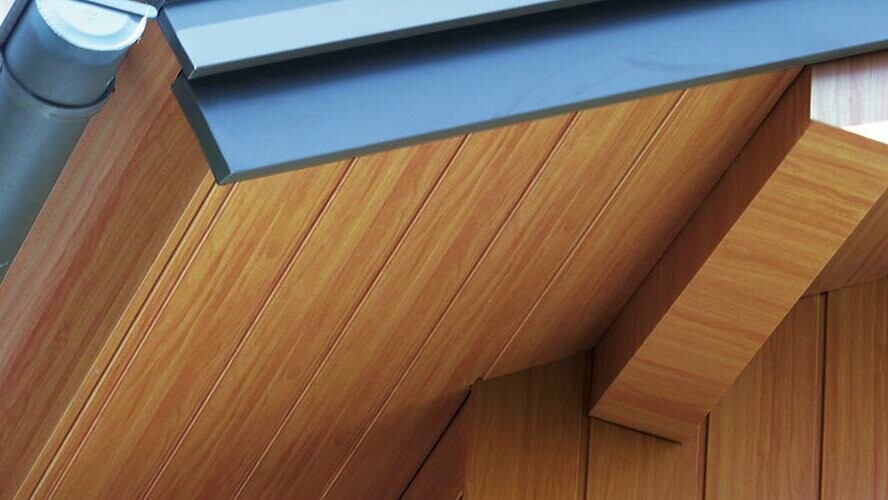 Intradosso del tetto rivestito con doghe di rivestimento PREFA di colore legno chiaro in alluminio.