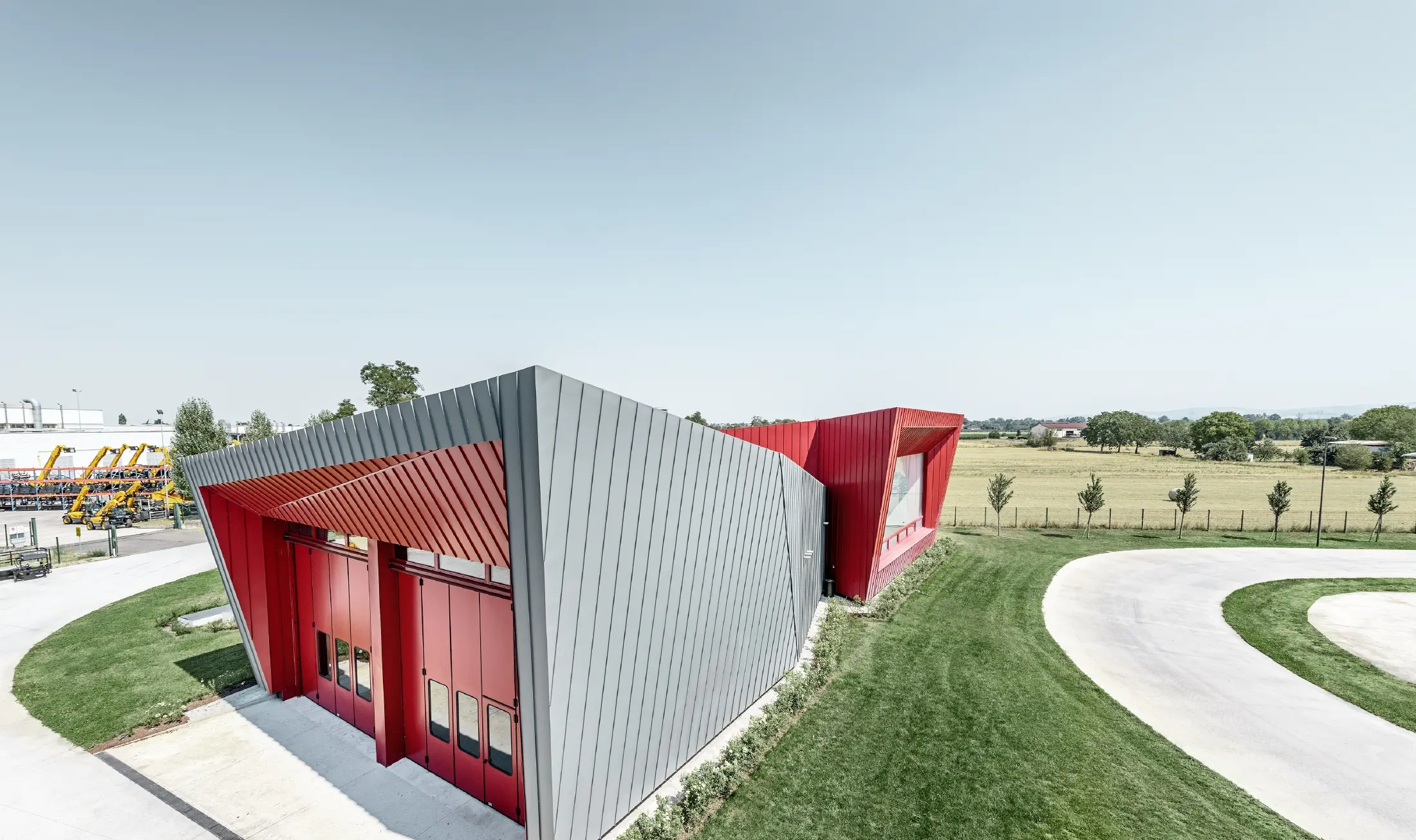Centro allenamenti moderno di Dieci a Montecchio Emilia (Italia) con tribuna con facciata in alluminio Prefalz in grigio chiaro e Falzonal in karminrot.