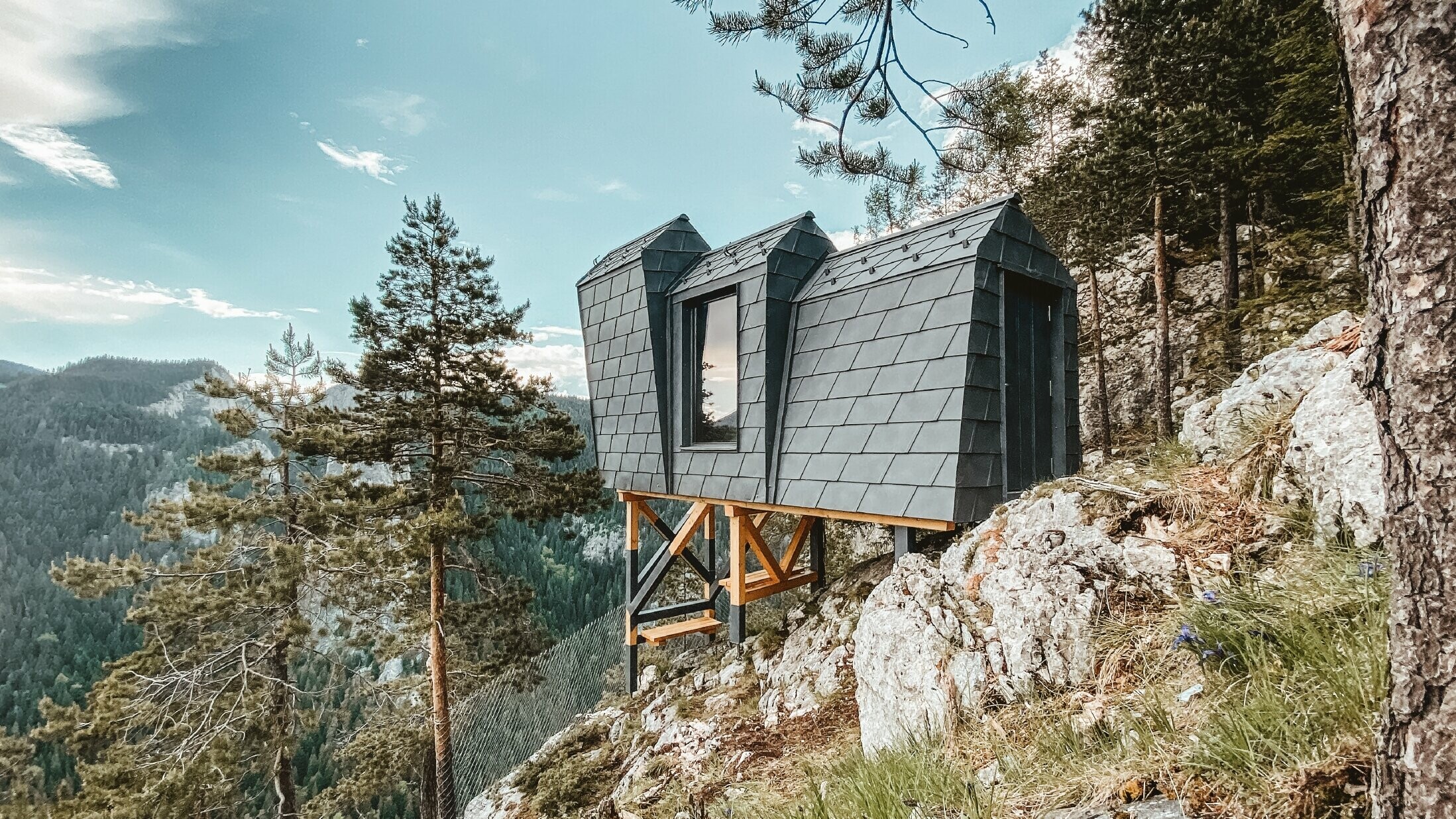 Biwak, vom Architekten entworfen, in exponierter Lage ist komplett mit der Aluminiumschindel DS.19 von PREFA in Steingrau verkleidet.