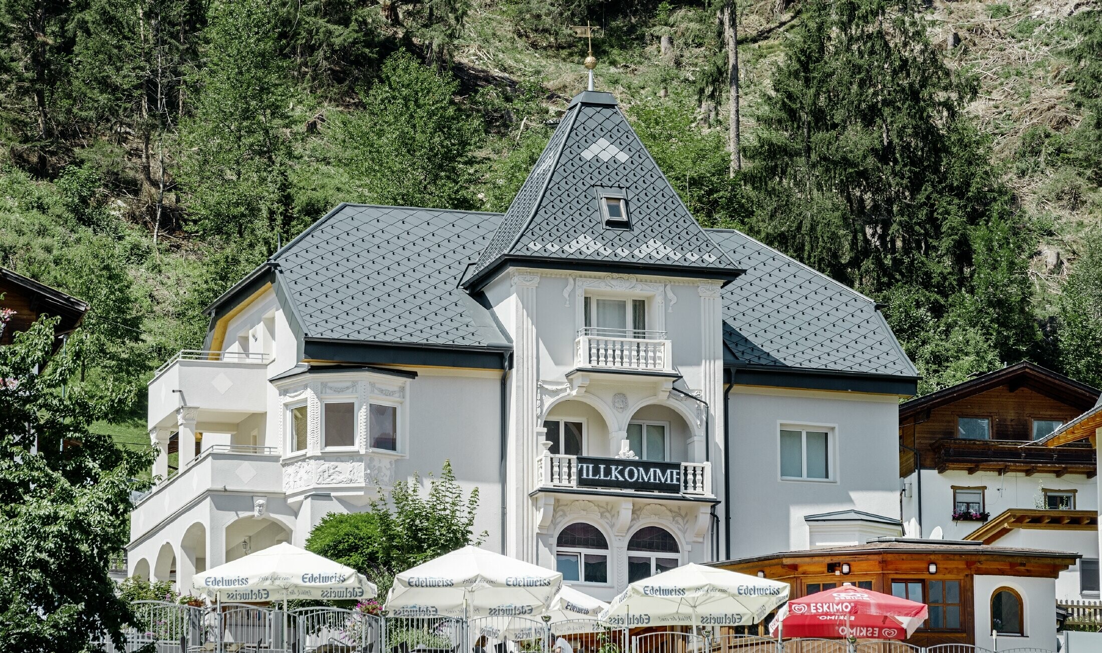 Felsenhaus mit Turm und einem Aluminiumdach in anthrazit mit einer Pizzeria im Erdgeschoss