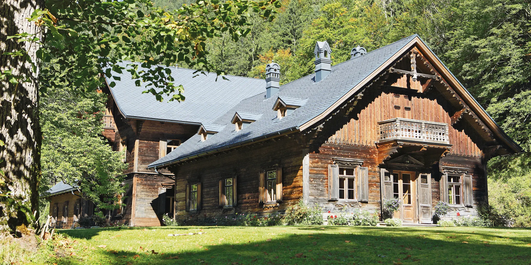Rothschildhaus in Langau bei Gamin: Forst- und Jagdhütte mit hochwertigem Blechdach aus PREFA Dachschindeln in Anthrazit. Das Holzhaus fügt sich harmonisch in eine malerische Waldlandschaft ein.