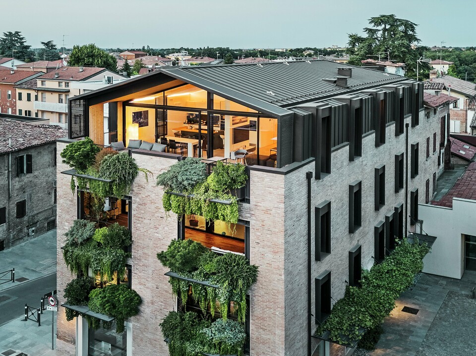 Nachhaltiges Wohnhaus in Italien mit PREFALZ Aluminiumdach und begrünter Backsteinfassade.