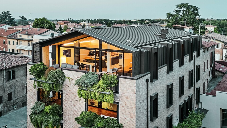 Nachhaltiges Wohnhaus in Italien mit PREFALZ-Aluminiumdach und grüner Ziegelfassade.