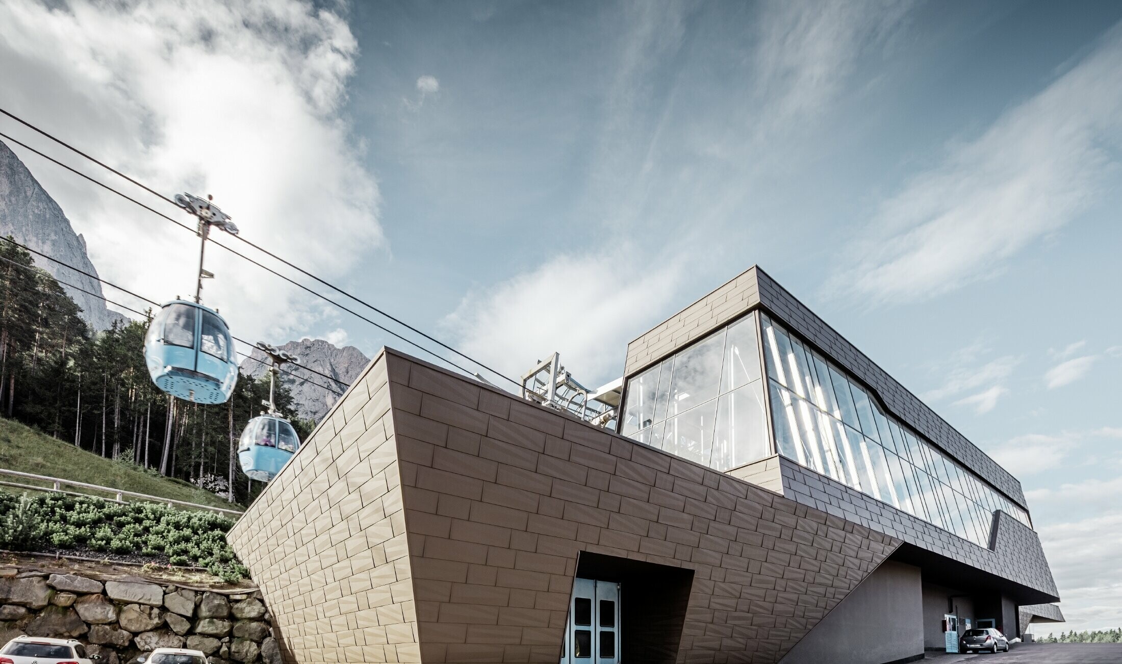 neu gestaltete Talstation der Umlaufbahn Seiser Alm, ähnlich der Dolomiten im Hintergrund mit unregelmäßigen Kanten und Oberflächen mit einer Aluminium Fassade in braun von PREFA