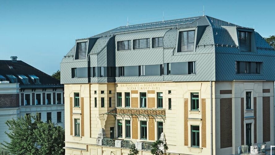 La storica Simony Haus a Vienna dopo la ristrutturazione con le scaglie per tetto e per facciata PREFA in P.10 grigio chiaro