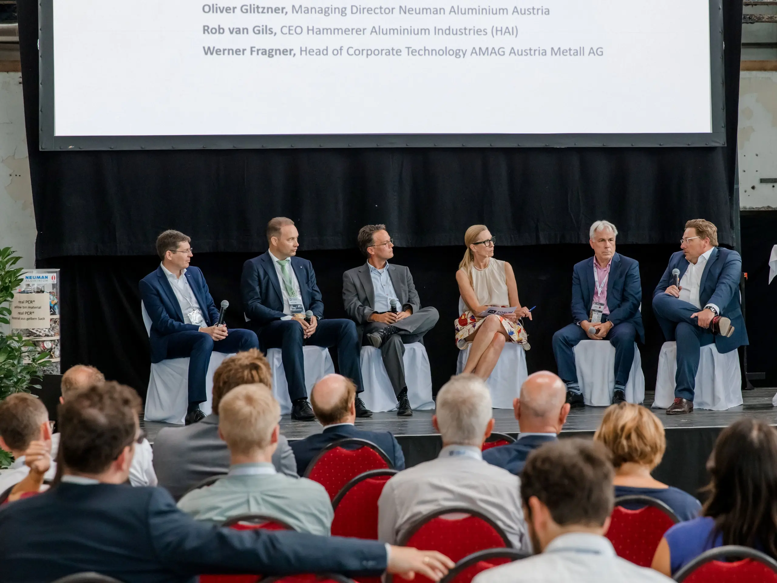 Bild einer Diskussionsrunde mit 5 Personen, die sich während der Konferenz "Forum Aluminium" über die Aluminiumindustrie in Europa austauschen.