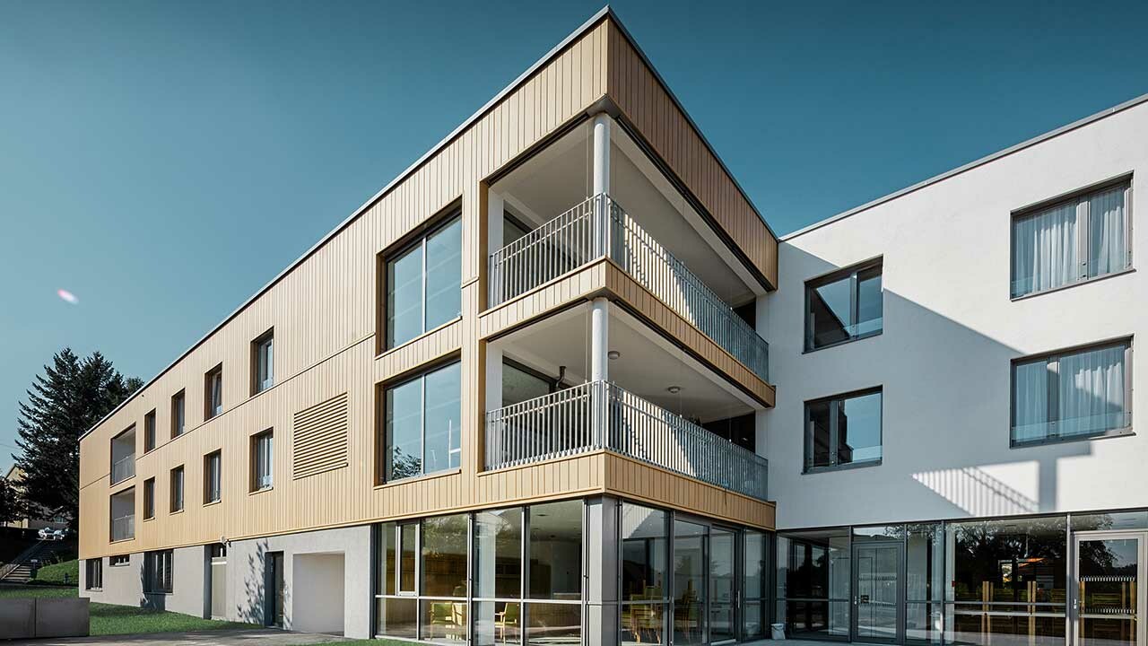 Altersheim mit Flachdach und einer sandbraunen Sidingsfassade von PREFA