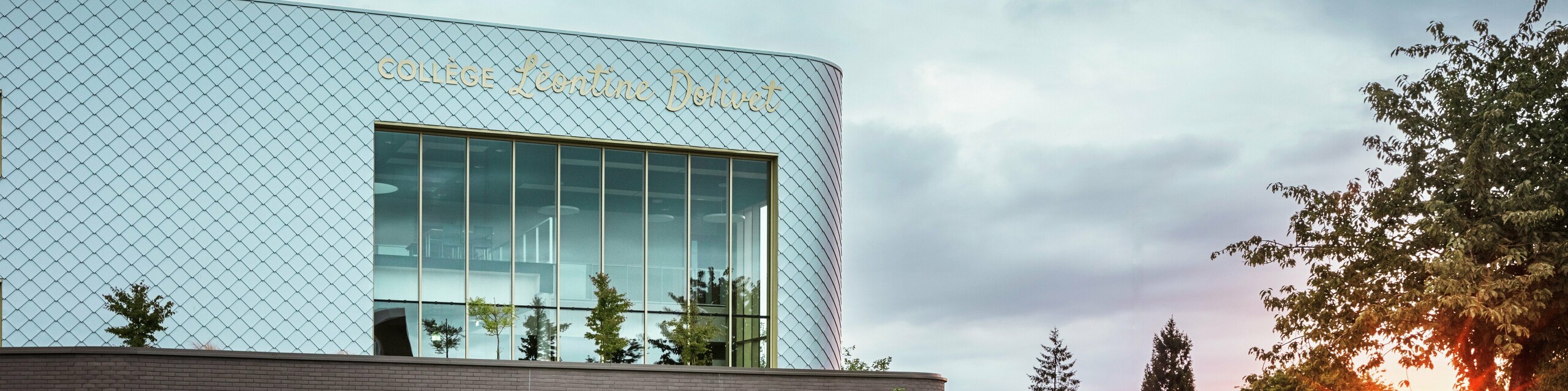 Modernes Schulgebäude Collège Léontine Dolivet in Cesson-Sévigné mit markanter Aluminiumfassade aus rund 15.000 PREFA Wandrauten in Silbermetallic. Die schimmernde Oberfläche reflektiert das Licht und erzeugt ein lebendiges, elegantes Erscheinungsbild. Große Glasfronten öffnen den Blick ins Grüne, während die robuste PREFA Fassadenlösung Langlebigkeit und Witterungsbeständigkeit garantiert. Die Kombination aus changierendem Metall und klarer Architektur macht das Gebäude zu einem echten Eyecatcher und unterstreicht die Vorteile von Aluminium: leicht, wartungsfrei und nachhaltig.