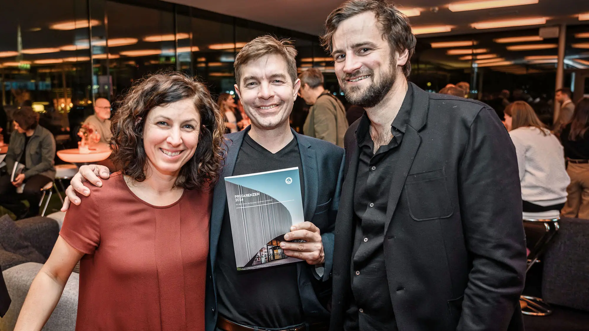 L'architetto Claudia Gast, l'architetto Mario Dallaserra con in mano il libro PREFARENZEN 2024, e l'installatore Simon Mössler.