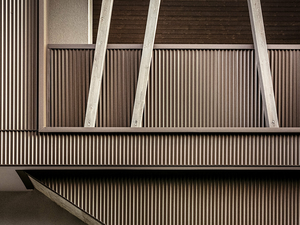 Primo piano della facciata in alluminio con profilo a zeta e travi in legno inclinate della villa 2B a Morbegno, ristrutturata dall'architetto Massimo Mescia di altrostudio architetti.