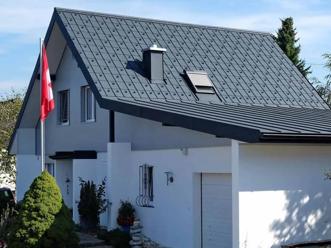 Casa con garage dopo la ristrutturazione del tetto con tegole PREFA antracite