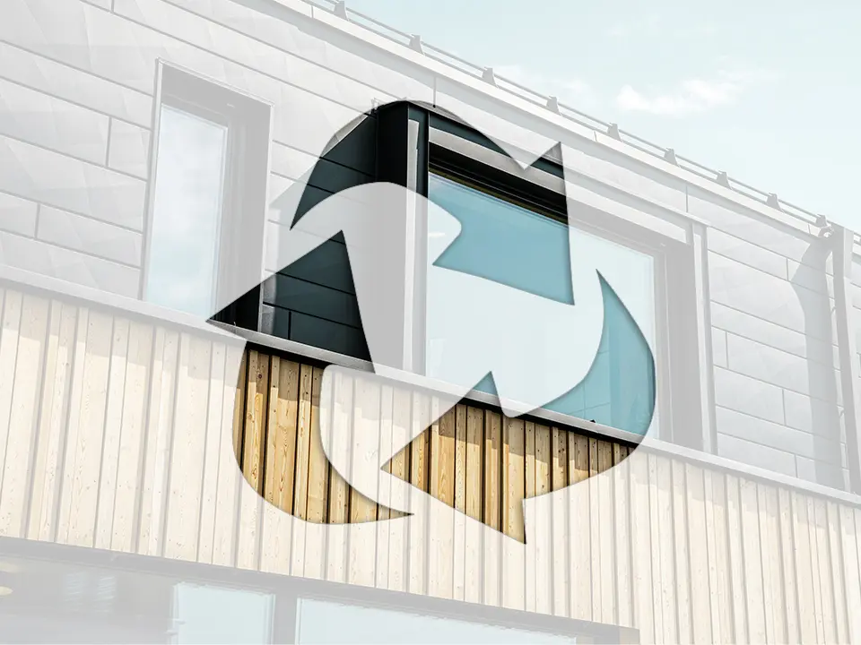 Foto zeigt das Recycling-Symbol vor einer Hausfassade mit PREFA Aluminium-Elementen und Holzpaneelen.