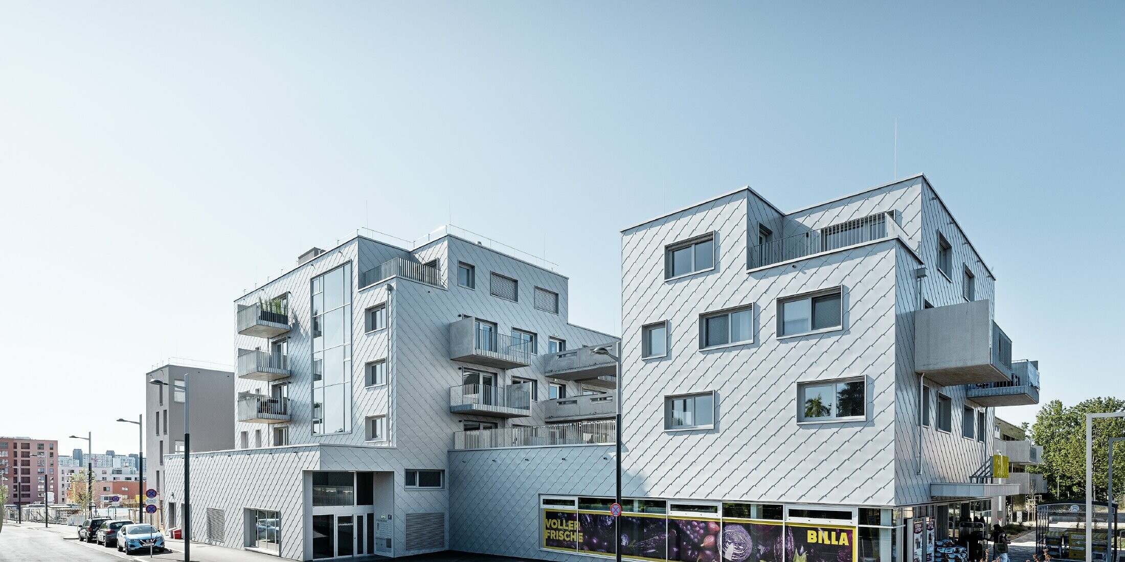 Edifici residenziali con tetto piano e rivestimento a scaglie sulla facciata con la scaglia PREFA 44 × 44 in silver metallizzato