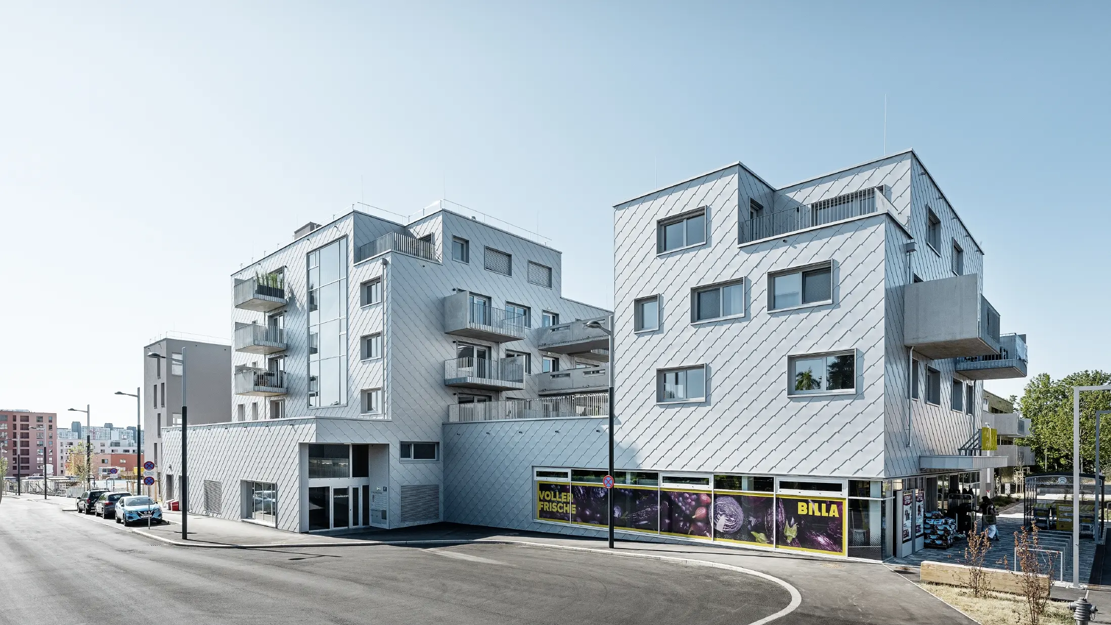 Wohnhausanlagen mit Flachdach und Rautenverkleidung an der Fassade mit der PREFA Wandraute 44 × 44 in Silbermetallic