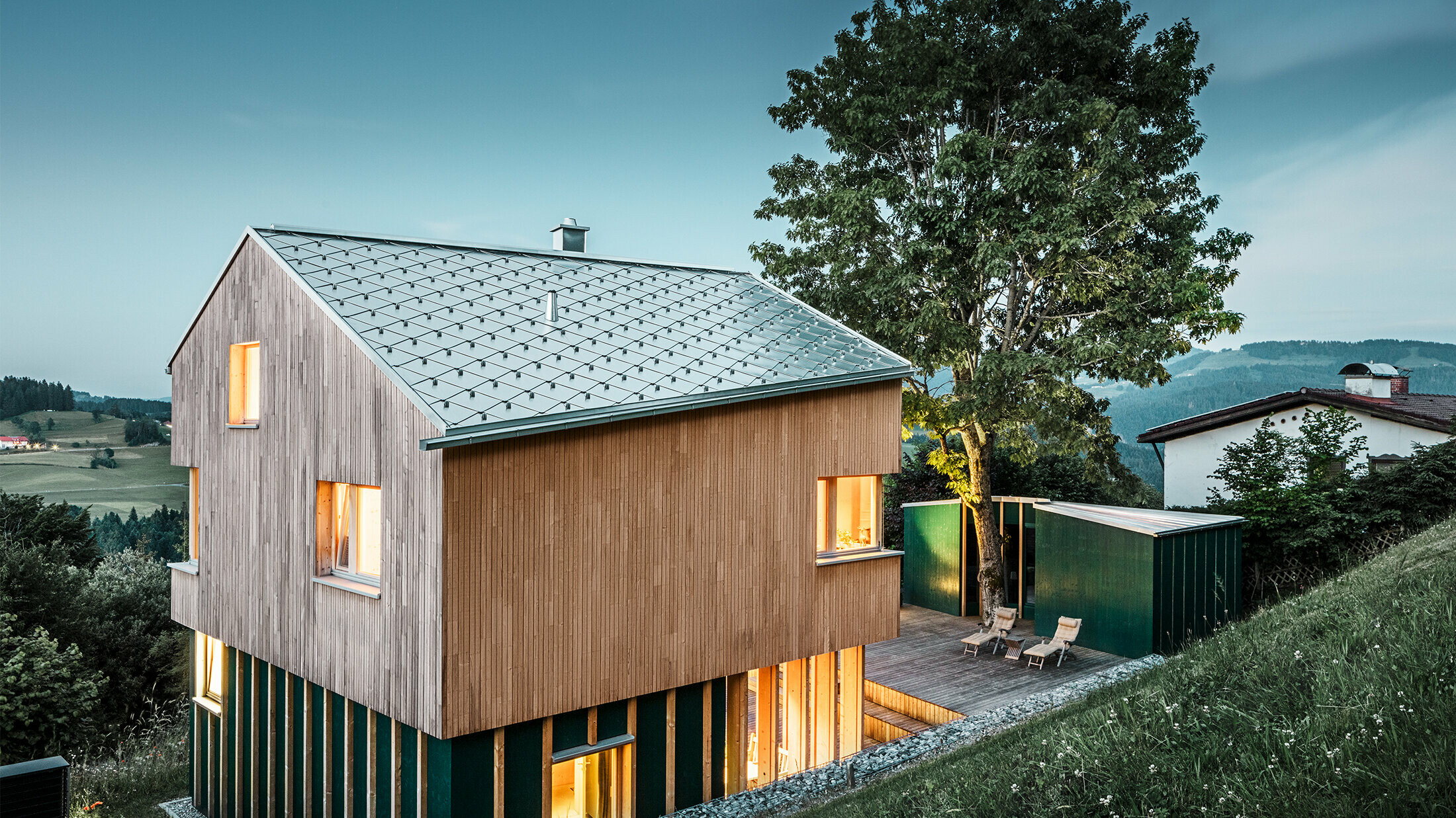 Neugebautes Einfamilienhaus mit Holzfassade und naturblankem PREFA Dach in Rautenform