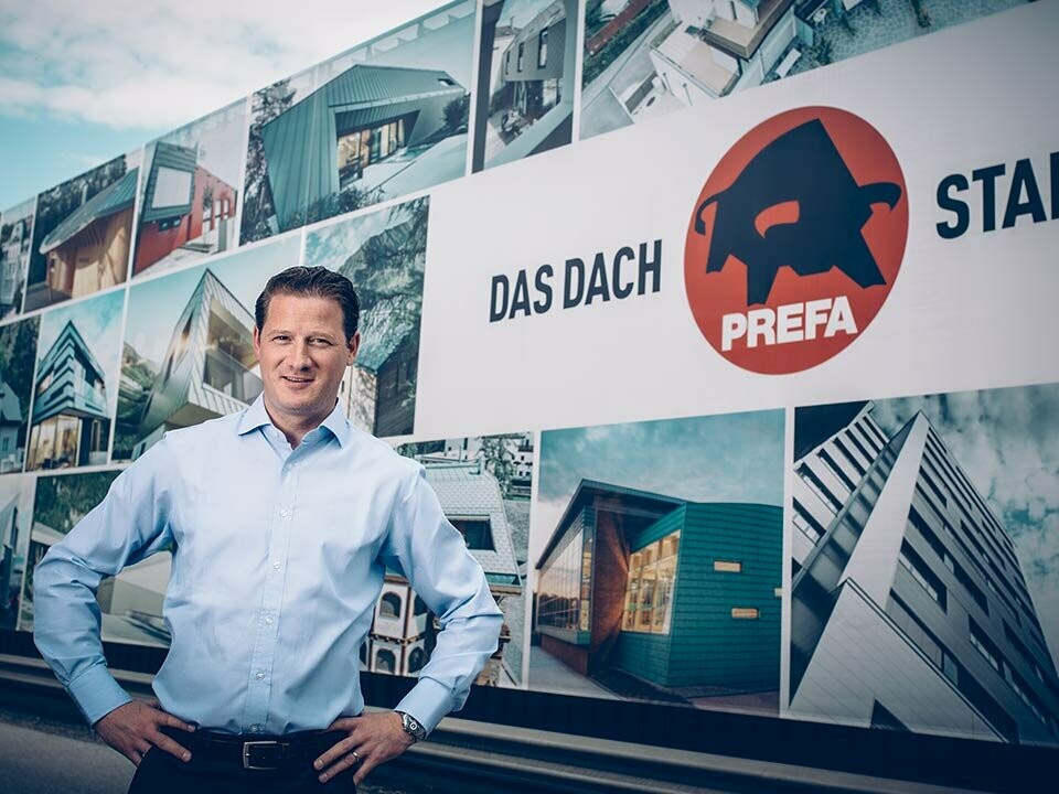 Leopold Pasquali, amministratore delegato PREFA, davanti alla sede aziendale con logo PREFA.