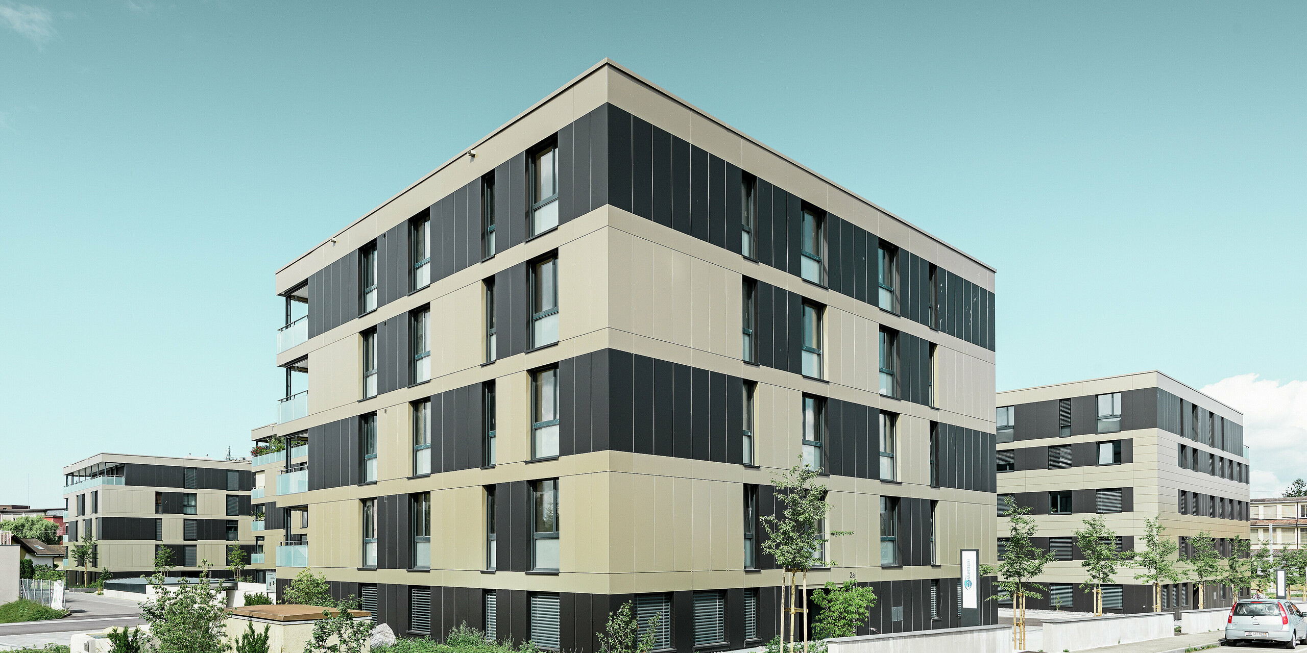 complesso residenziale cubiforme con facciata in alluminio in bronzo con elementi in nero opaco