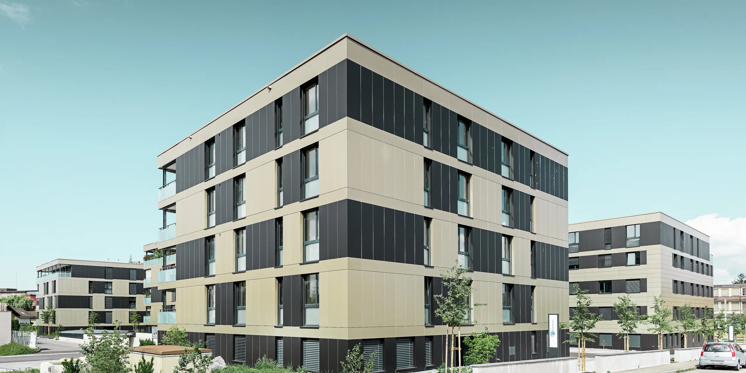 complesso residenziale cubiforme con facciata in alluminio in bronzo con elementi in nero opaco
