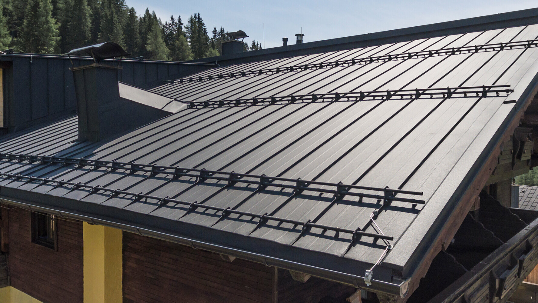 Sonnalm eingedeckt mit dunklen Aluminium Bandblech leichtes Dachsystem mit Schneeschutz