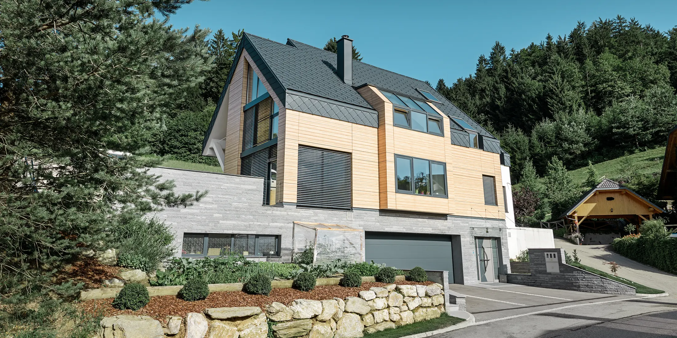 Einfamilienhaus mit Satteldach ohne Dachvorsprung mit einer Fassade in Holzoptik und einem Aluminiumdach in anthrazit